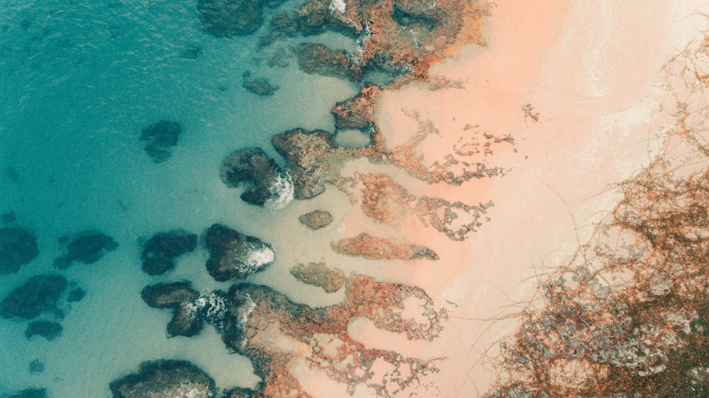 an aerial view of a beach with rocks and water