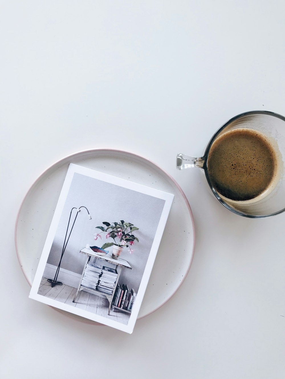 tasse en verre à côté d’une photo sur le dessus d’un plateau