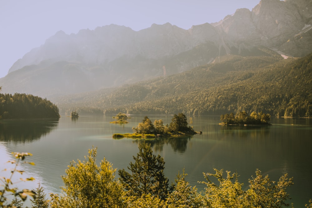 body of water within mountain range during fog