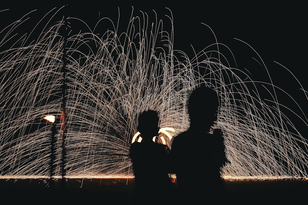 夜の花火大会の前でキスをする男女