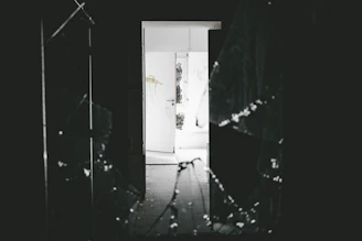 Emergency glass replacement team working on a broken glass door at night.