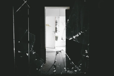 Emergency glass replacement team working on a broken glass door at night.