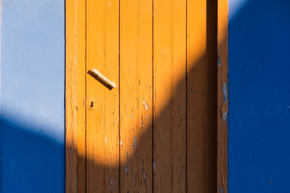 porta de madeira marrom ao lado da parede azul