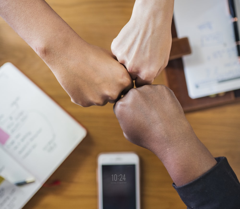 three person touching hand together