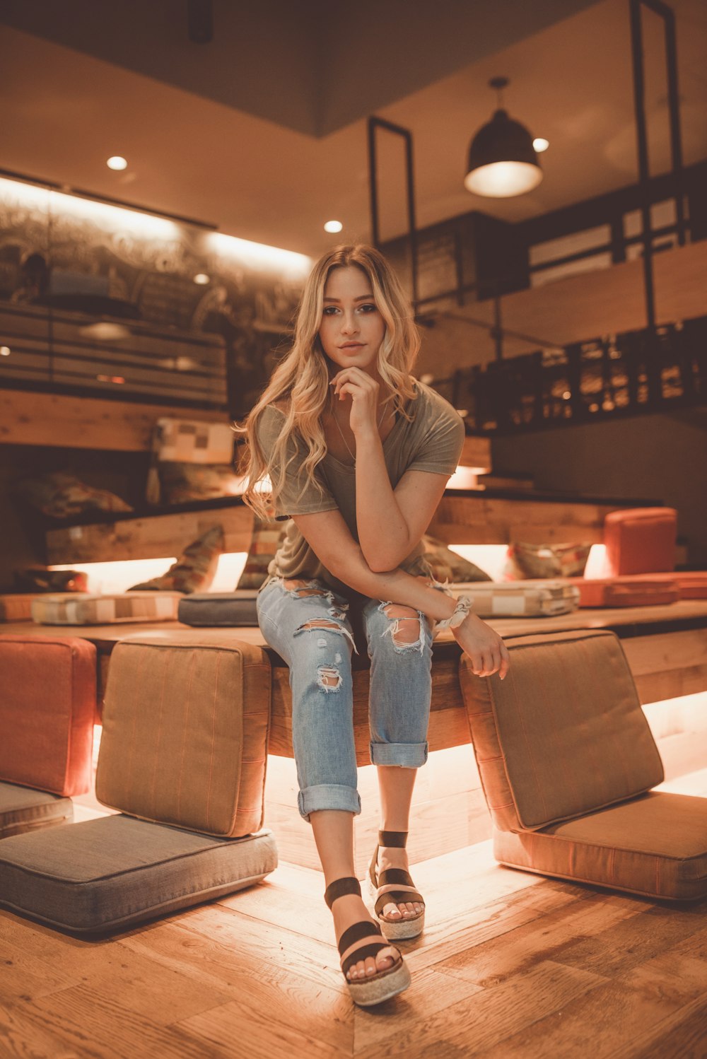 woman sitting between brown chairs