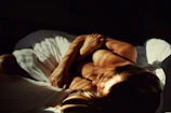 a woman laying on top of a bed next to a man