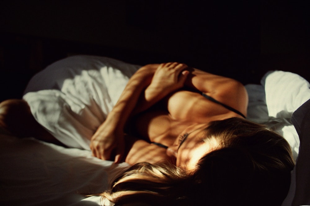 Una mujer acostada encima de una cama junto a un hombre