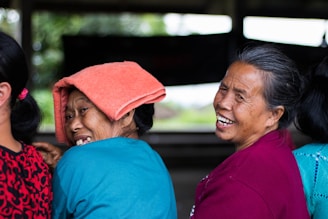 two women looking at the back while smiling and taking picture