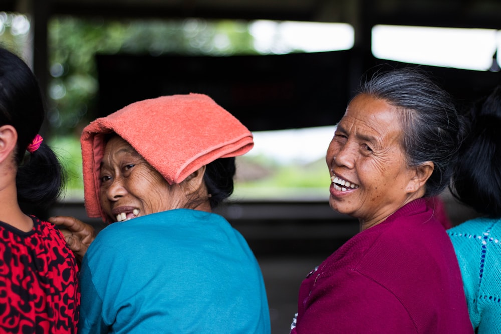 two women looking at the back while smiling and taking picture