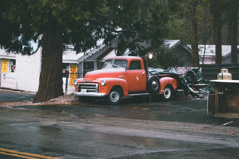 red single cab pick up truck parked near large tree