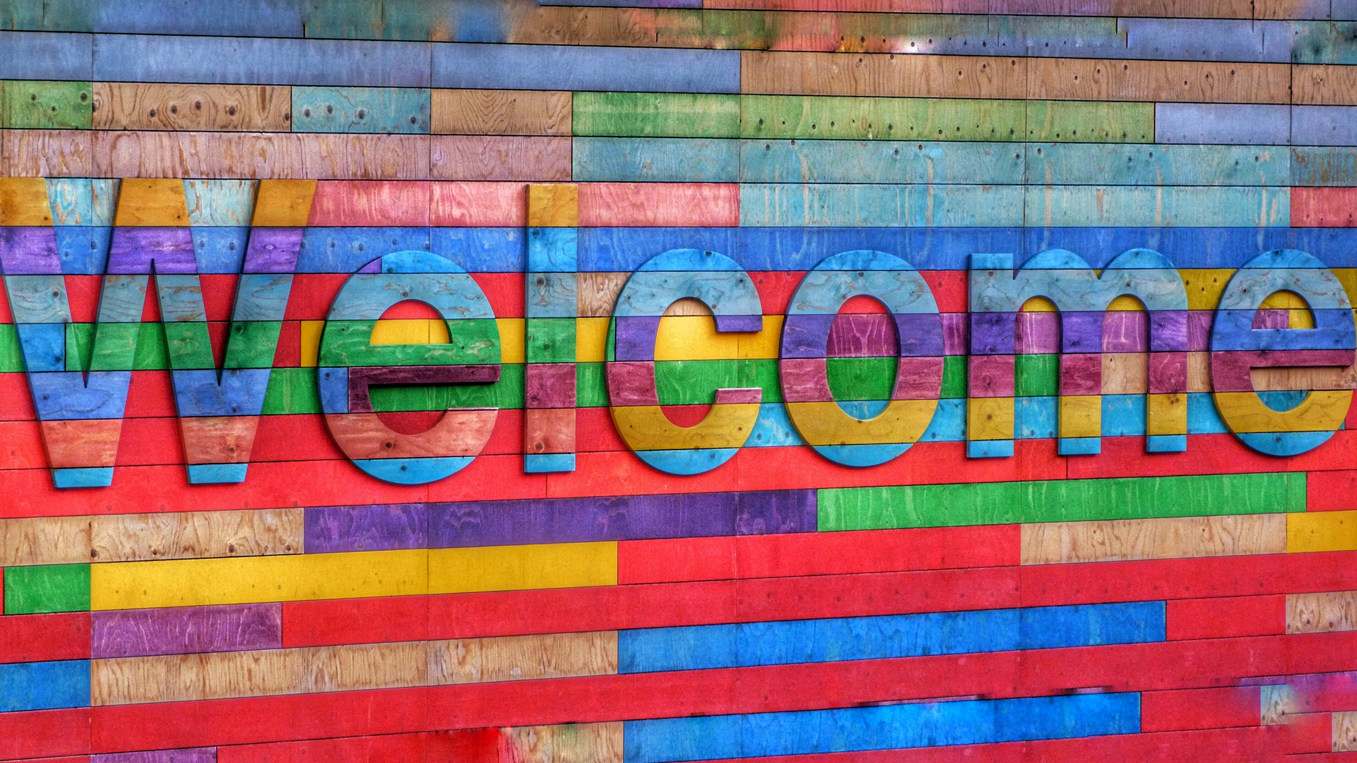 A colourful and welcoming sign that would make the majority of us feel welcome. Colourful and creative and an improvement on a plain wall.