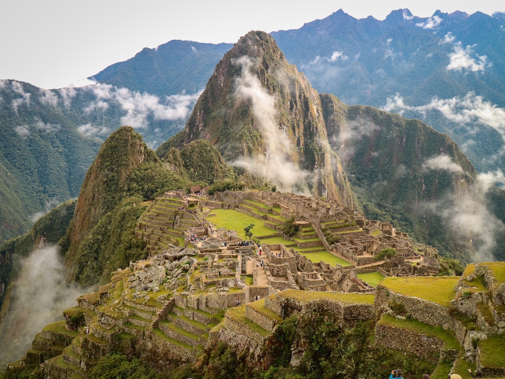 montaña verde y marrón bajo nubes blancas durante el día