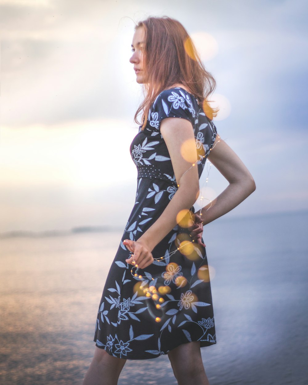 man wearing black and white floral dress while standing front of se a