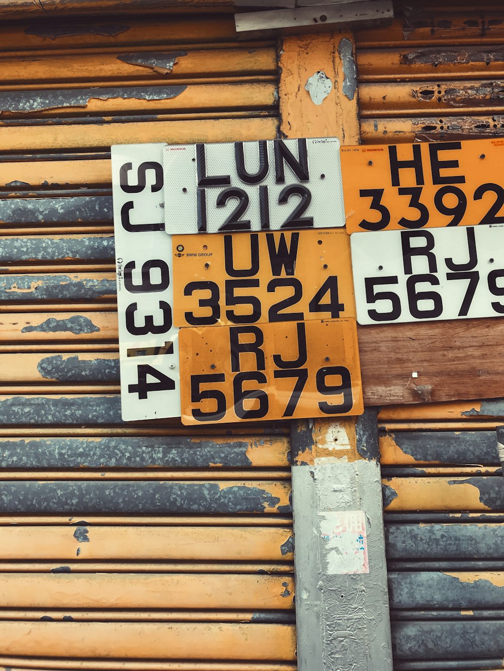 assorted license plates hanging on roller shutter