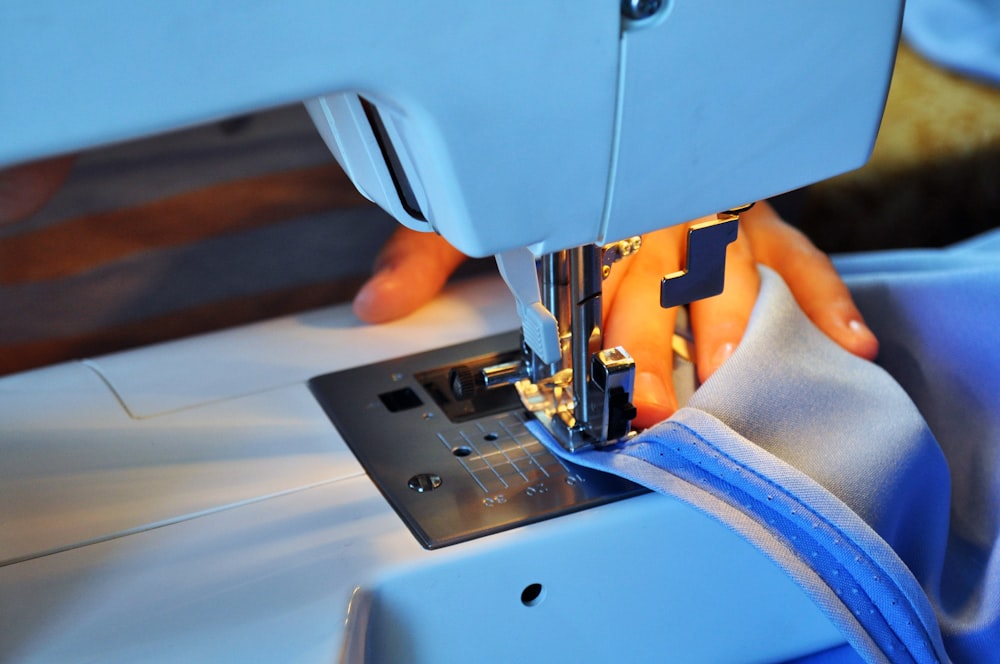 person sewing using sewing machine