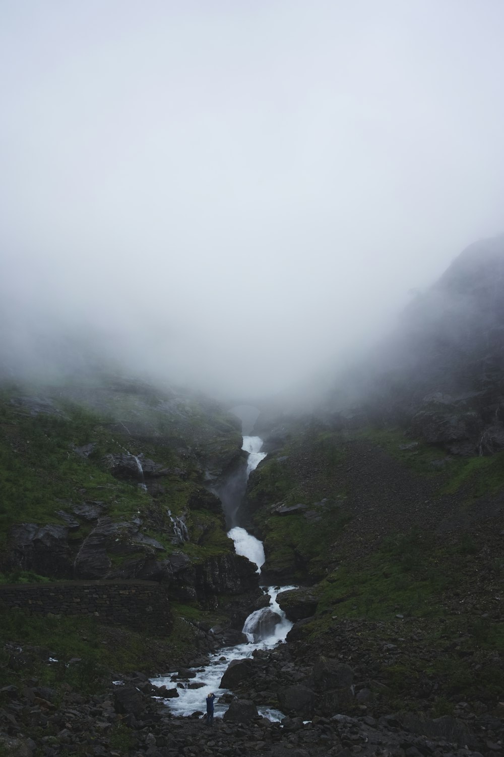 river in mountain with white fog