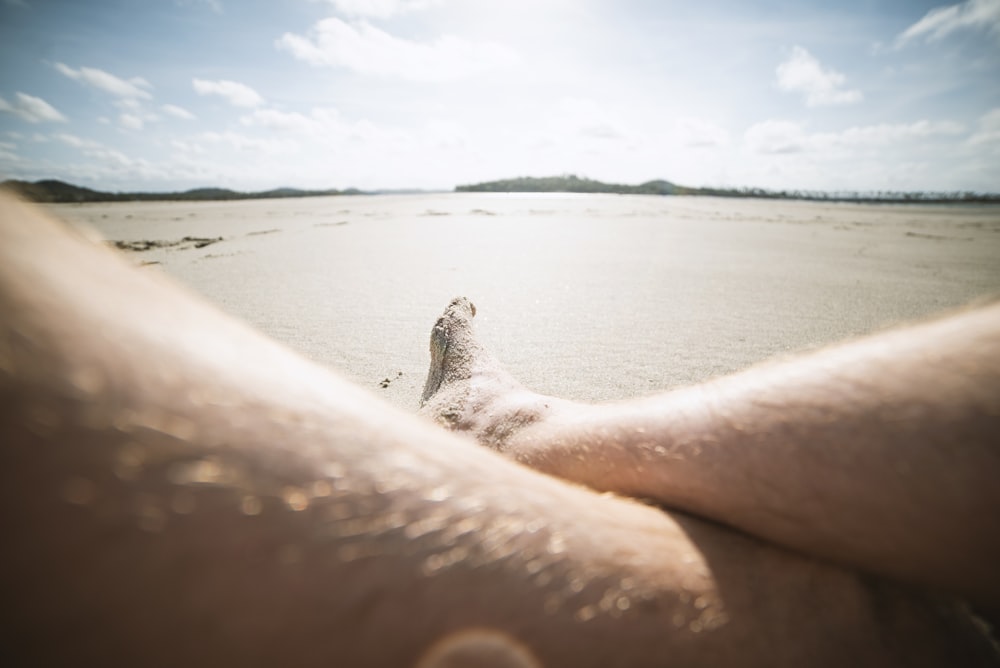a person's feet in the sand on a beach