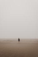 man standing on brown sand