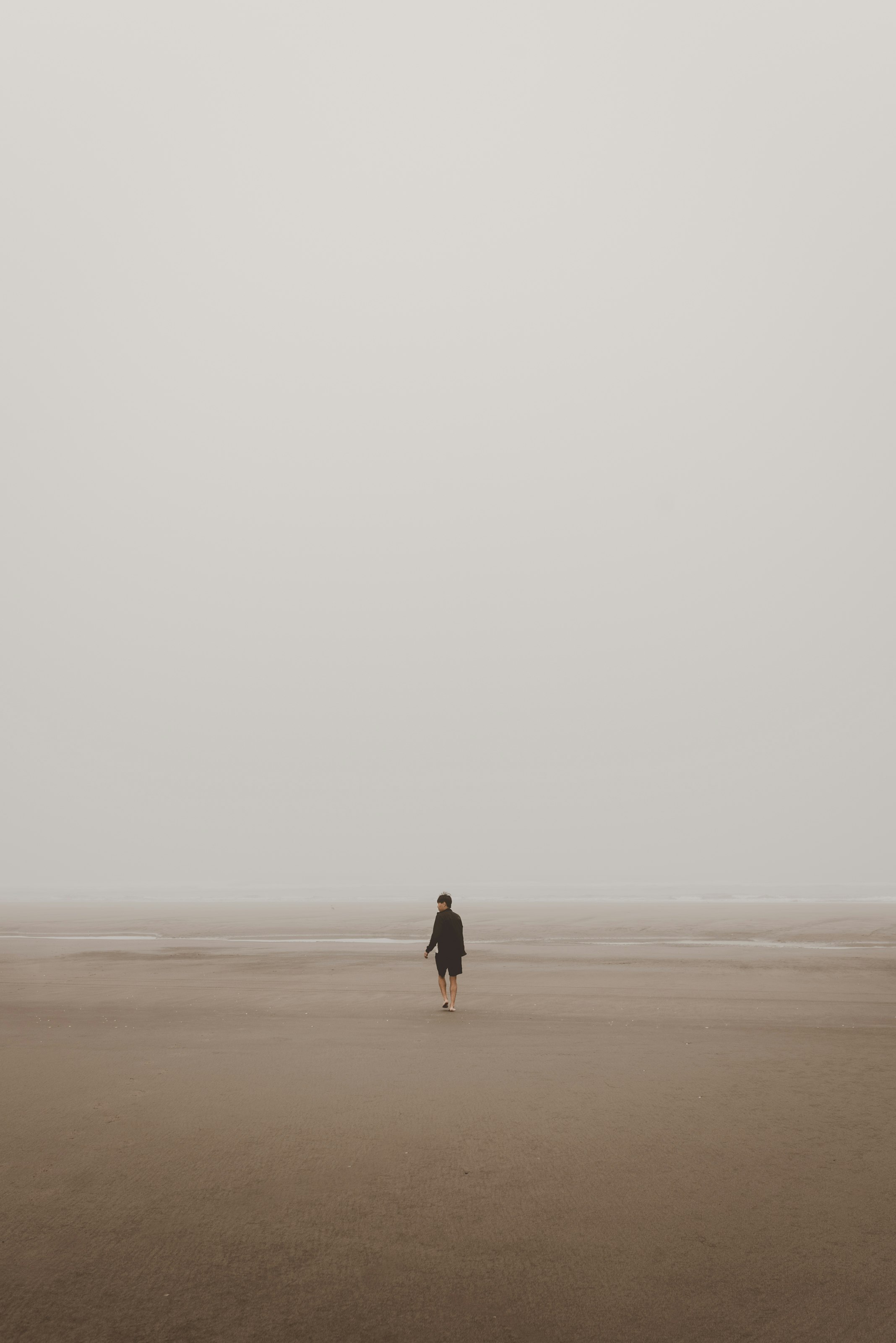 man standing on brown sand