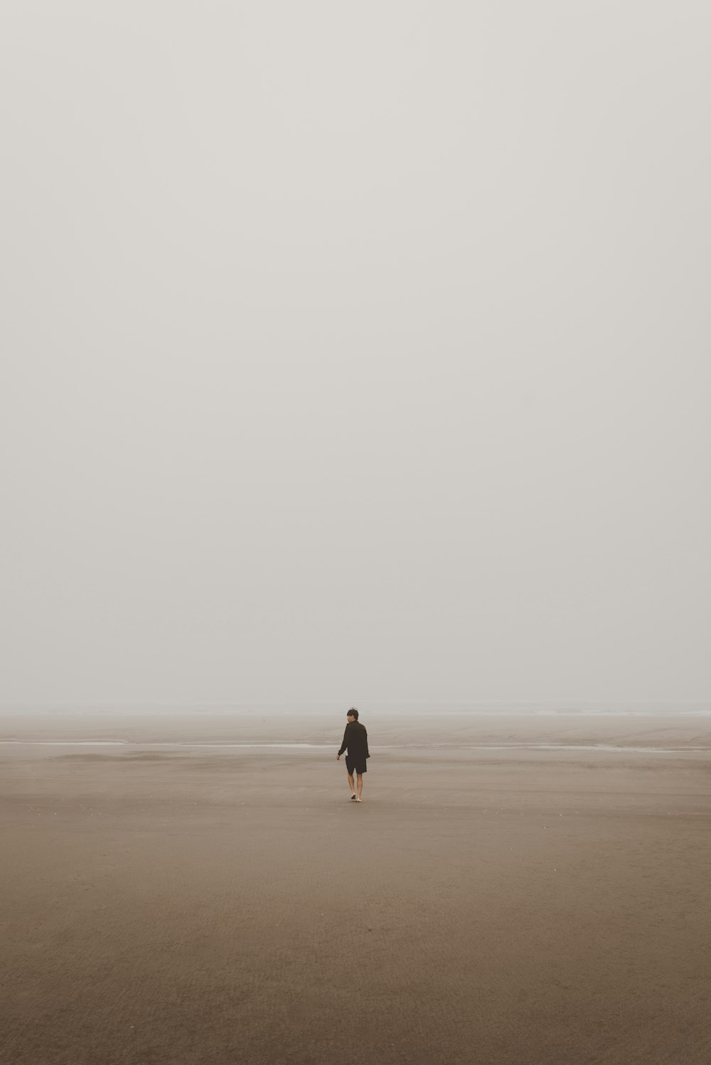 homme debout sur le sable brun