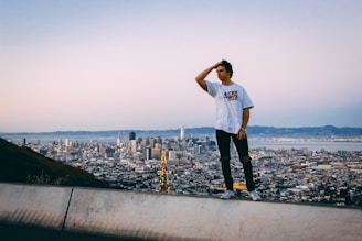 A thoughtful leader standing by a window overlooking a city skyline at dusk.