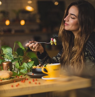 woman holding fork in front table