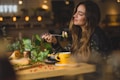 A happy woman enjoying a colorful plate of meat, fish, and vegetables in a cozy kitchen setting.
