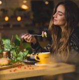 woman holding fork in front table