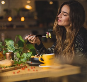 woman holding fork in front table