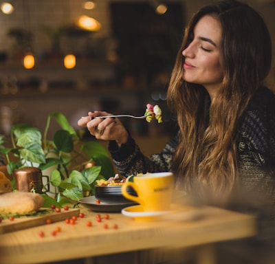 woman holding fork in front table