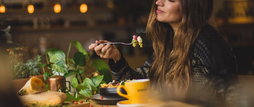 woman holding fork in front table