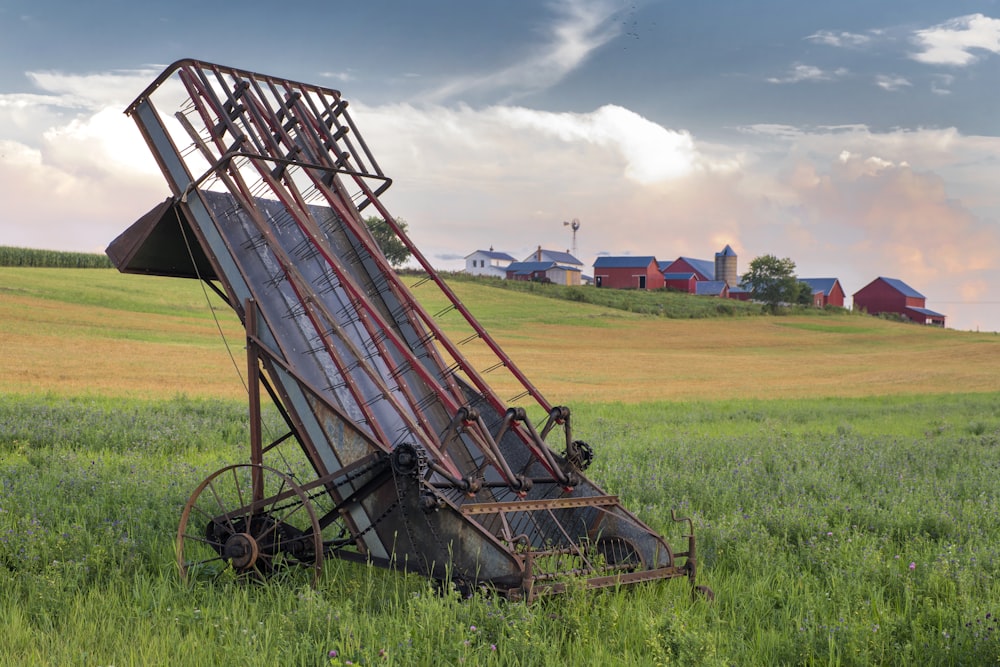 grey and red metal harvester machine on green field