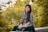 woman sitting on ledge surrounded by trees