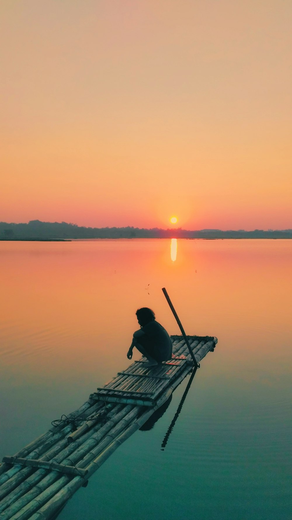 person sitting on bamboo boat