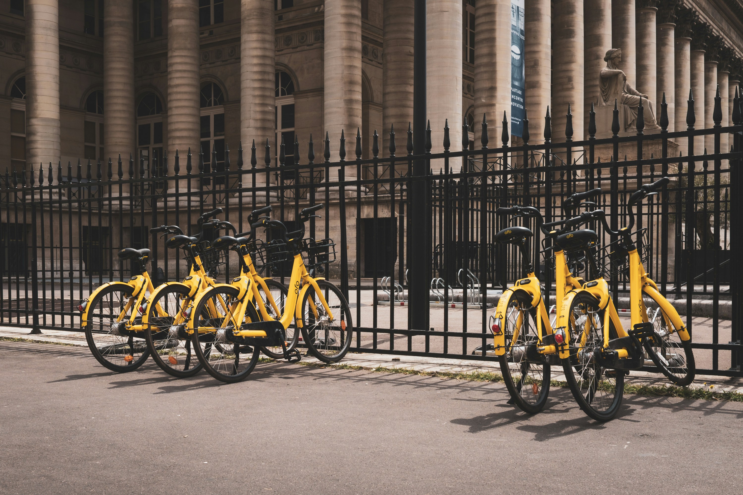 yellow bicycles beside black fence