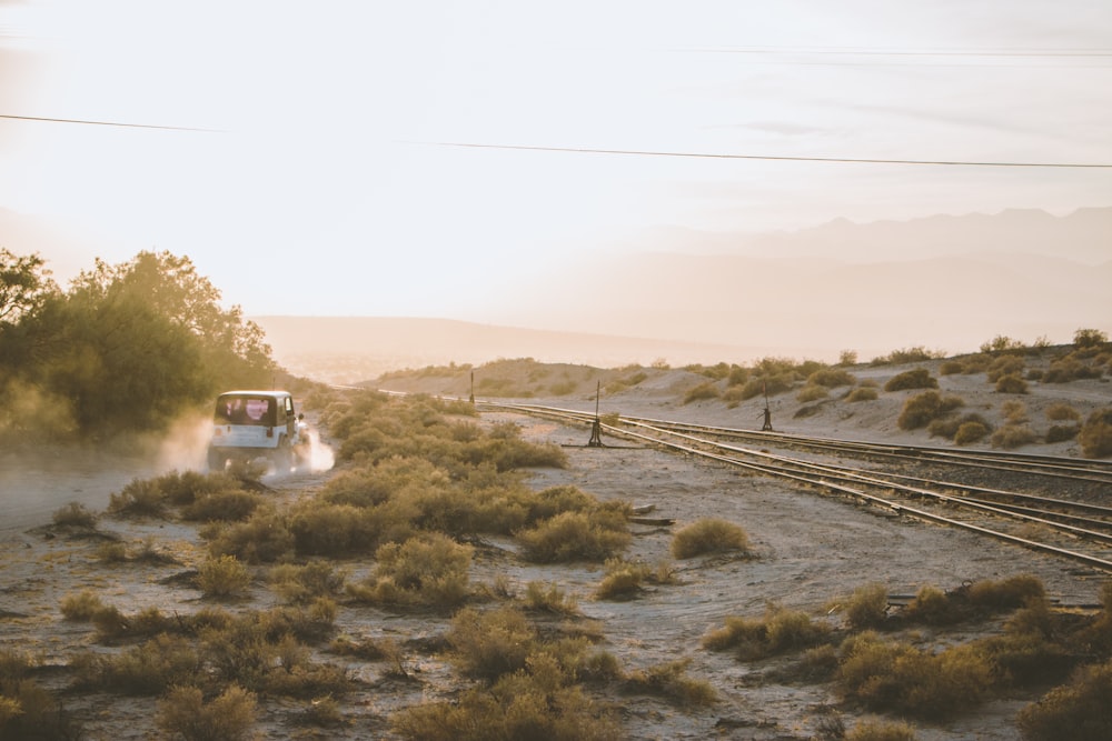 white car near train rail