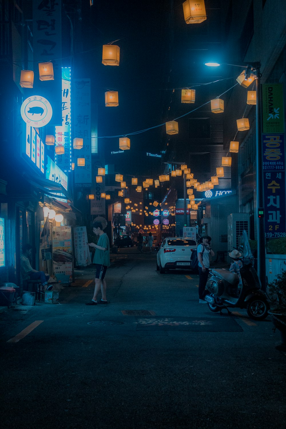 man standing on street while holding smartphone