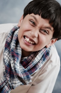 Close-up of a smiling child showing braces, with soft pastel colors in the background.