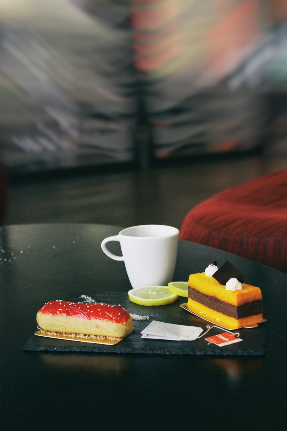 two piece of cakes and white mug on glass-top table