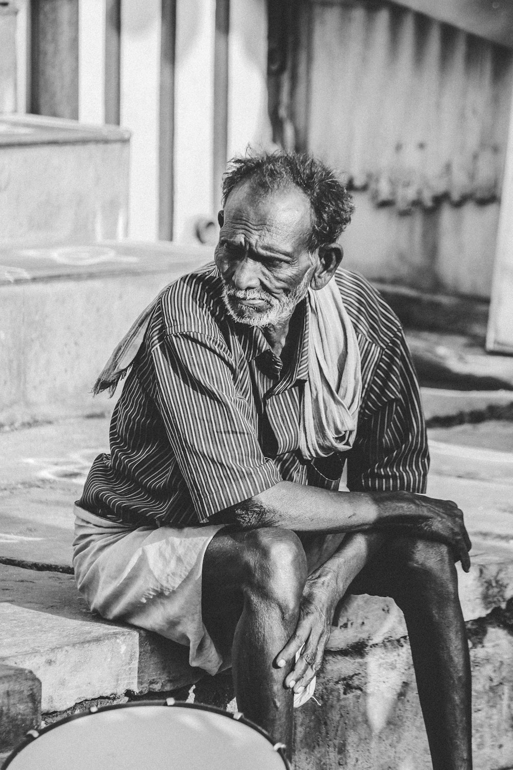 grayscale photo of man sitting on stairs