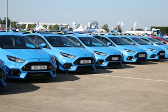 A row of various rental cars lined up neatly at the Detling Aerodrome Estate lot.