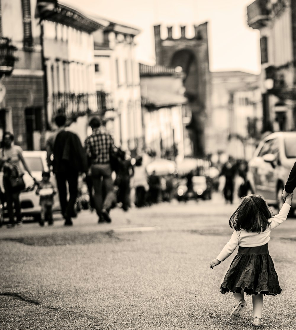 grayscale photography of child walking on pavement