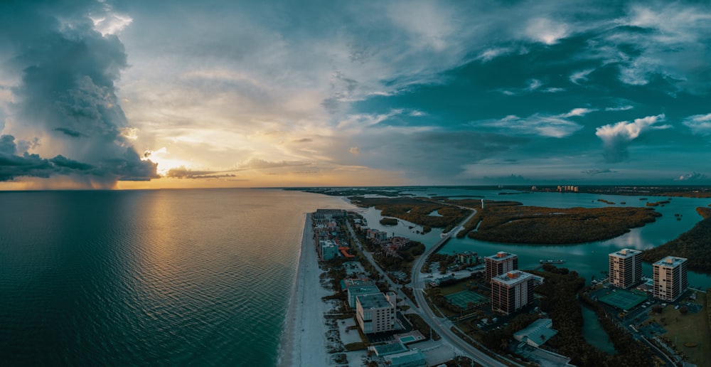 gray concrete buildings near body of water at golden hour