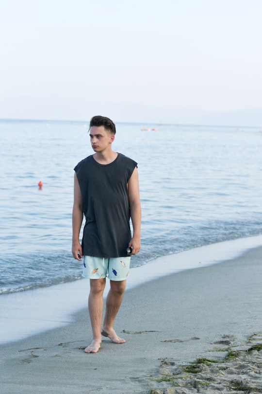 man walking on shore in Paralia Greece