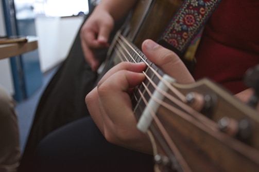 A close-up of hands strumming a guitar.