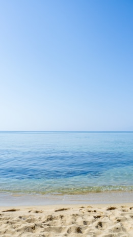 A serene beach view with clear blue waters and soft white sand, inviting relaxation and adventure.