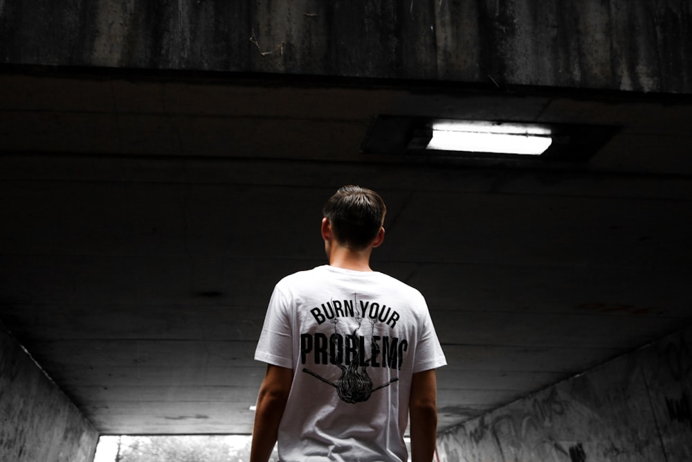 man wearing white and black shirt standing looking up