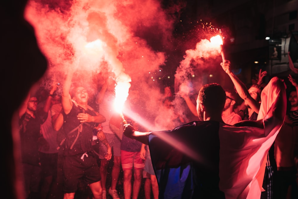 people holding firecrackers at night