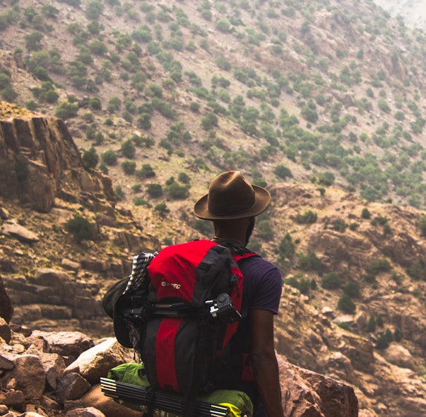 man hiking on brown mountain