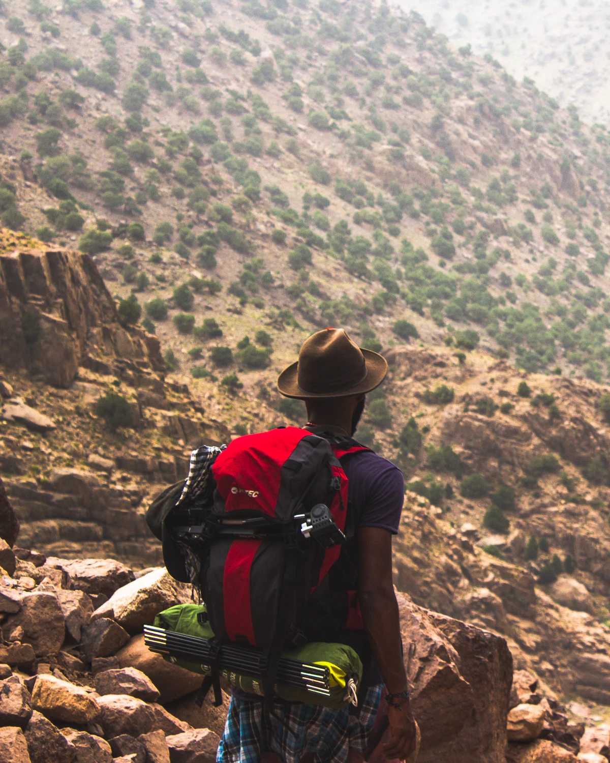 Man hiking on a brown mountain trail above Imlil, High Atlas, Morocco